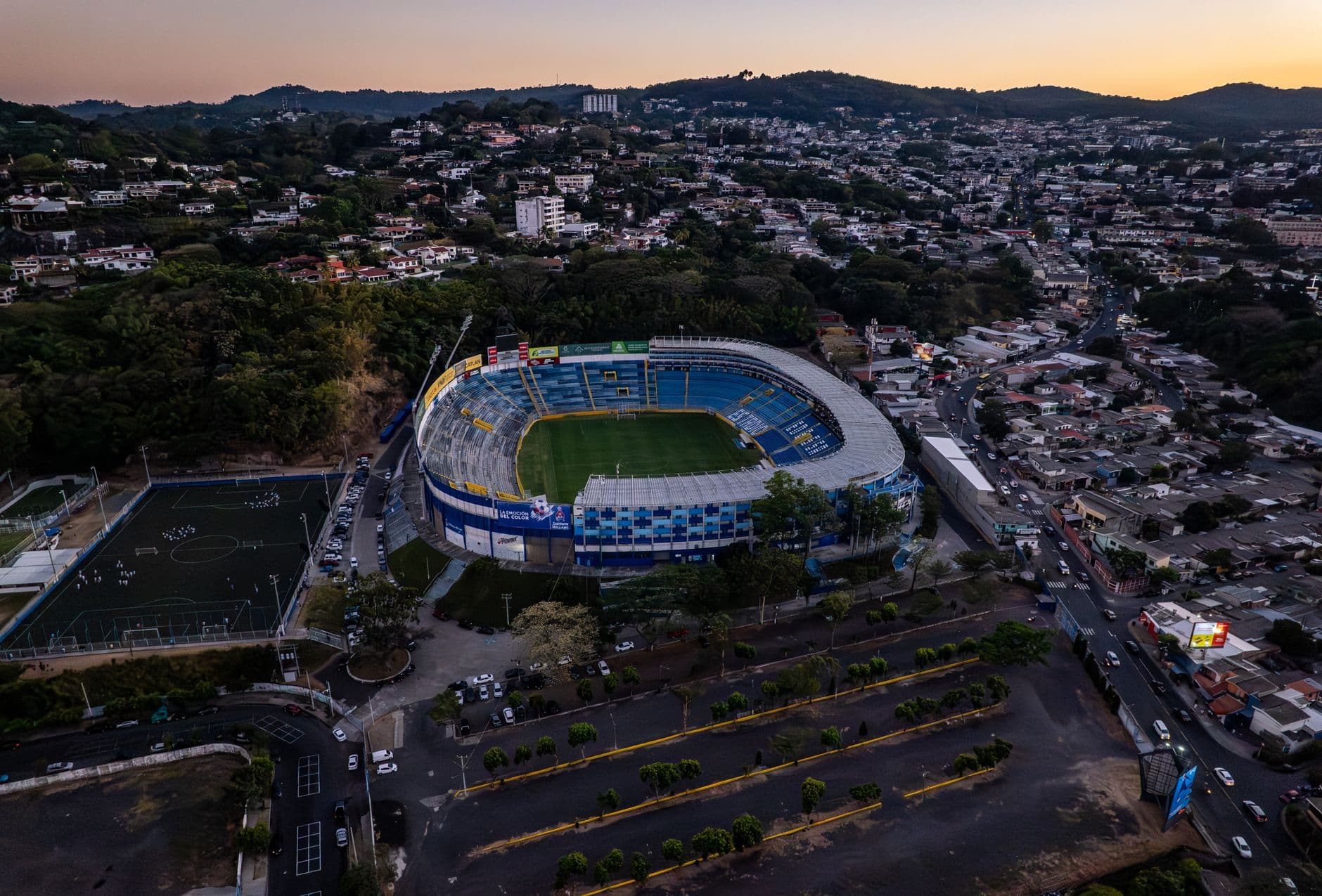 Aerial shot of Estadio Cuscatlán and surrounding area in San Salvador at sunset.
